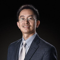 Hongyu Miao smiling wearing dark blue suit jacket, light blue dress shirt and a silver tie. Black background.